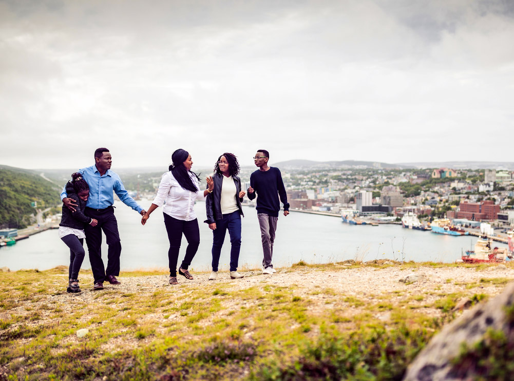 A family enjoys a stroll on Signal Hill, St. John’s walking past charming structures that overlook the Atlantic