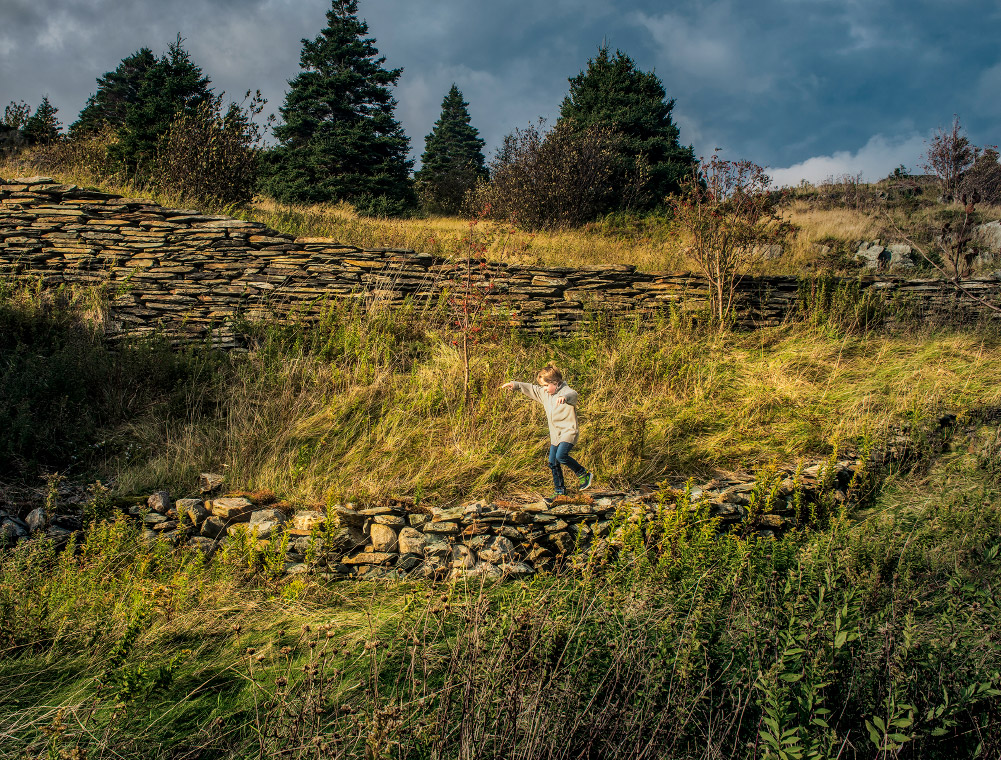 Child running on a grassy field in French’s Cove, Newfoundland and Labrador