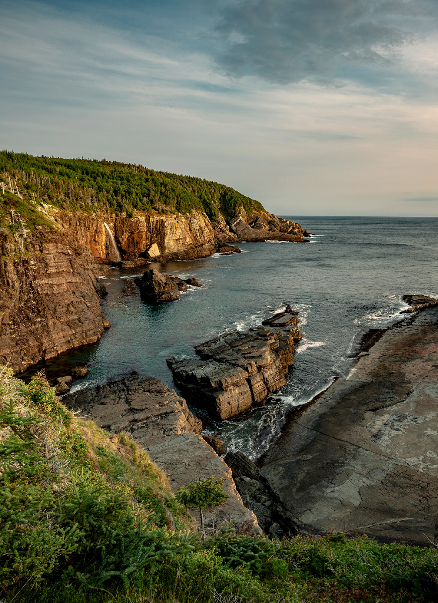 Rugged, rocky cliffs and a beautiful expanse of water at Stiles Cover Waterfall, Newfoundland and Labrador